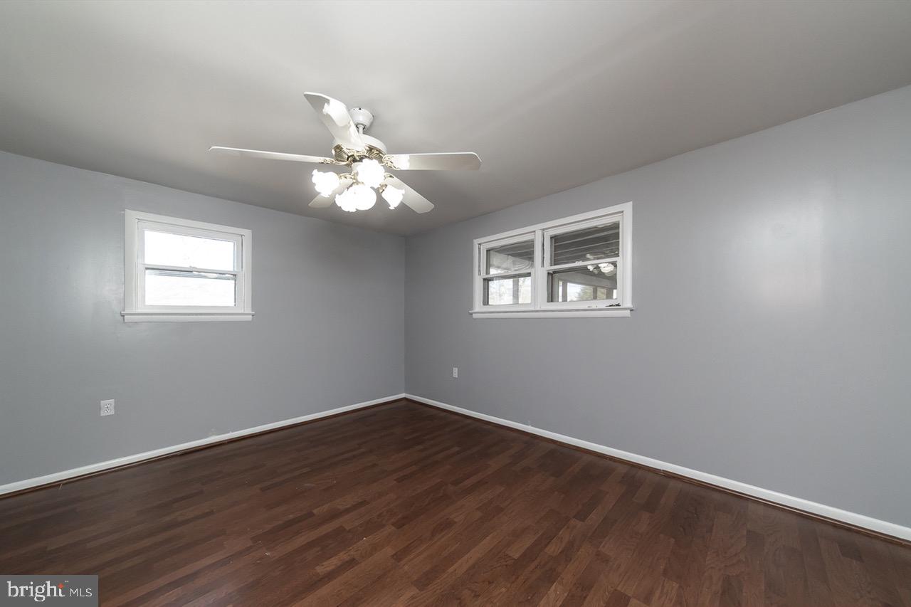 112 East 7th Avenue Pine Hill, NJ 08021 - Photo 14 of 27 a big room with wooden floor chandelier fan and windows