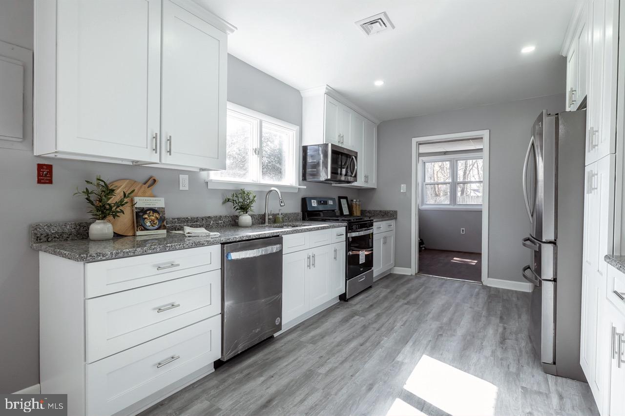 112 East 7th Avenue Pine Hill, NJ 08021 - Photo 2 of 27 a kitchen with granite countertop white cabinets and white appliances
