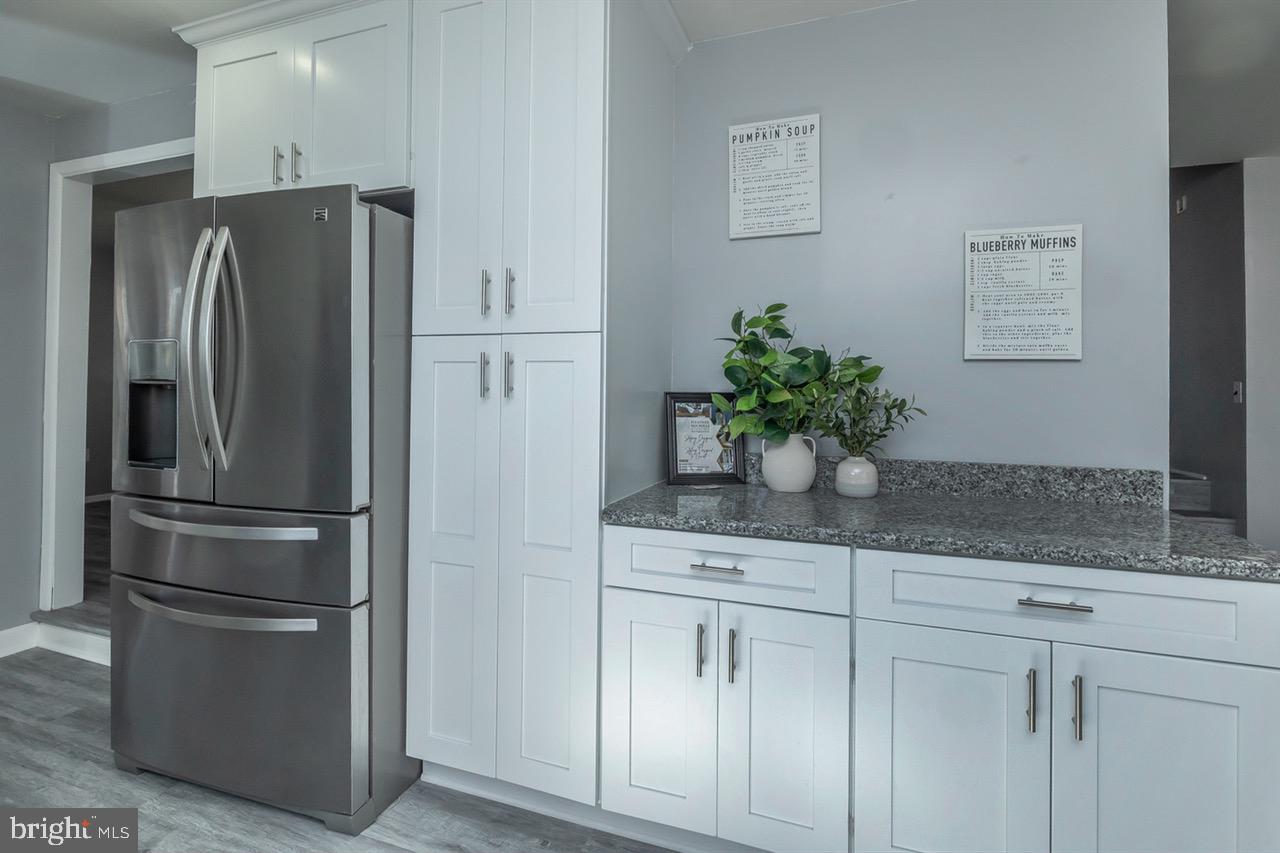 112 East 7th Avenue Pine Hill, NJ 08021 - Photo 6 of 27 a kitchen with stainless steel appliances white cabinets and a refrigerator
