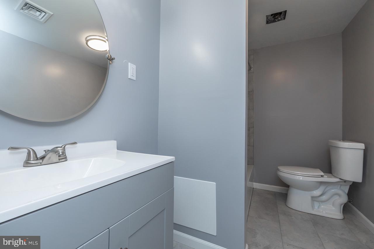112 East 7th Avenue Pine Hill, NJ 08021 - Photo 8 of 27 a bathroom with a sink a toilet and mirror