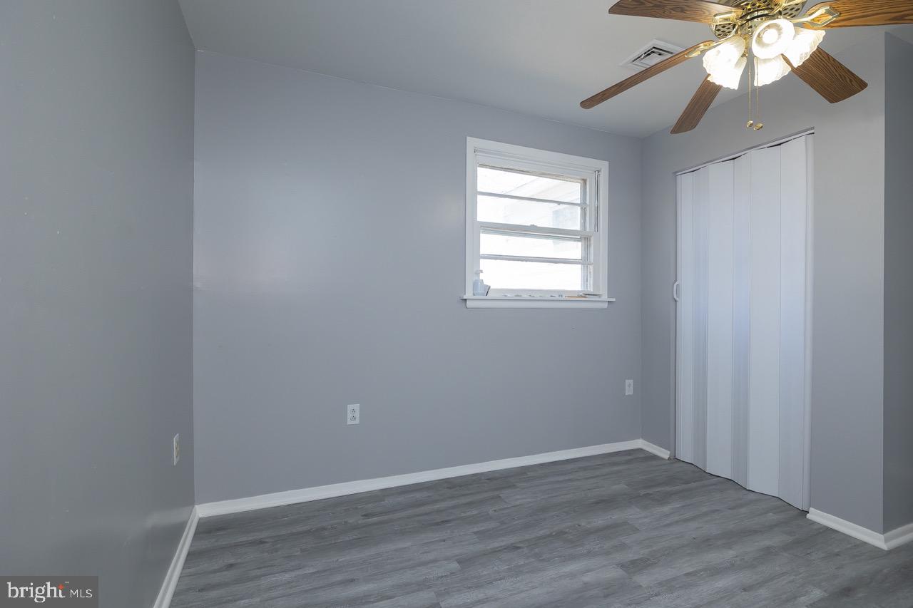 112 East 7th Avenue Pine Hill, NJ 08021 - Photo 10 of 27 an empty room with wooden floor and windows