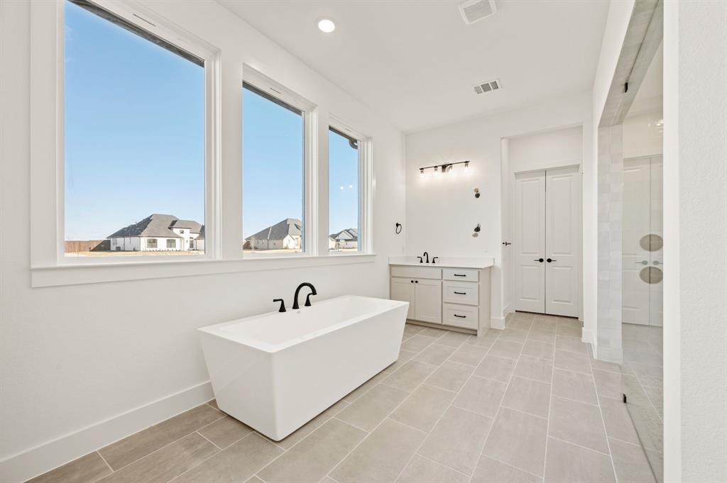 2139 Kingston Street Haslet, TX 76052 - Photo 22 of 40 a spacious bathroom with a double vanity sink a mirror and a bathtub