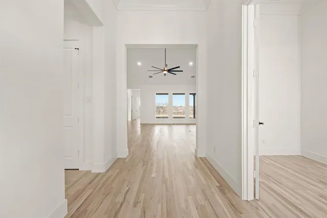 a view of a hallway view with wooden floor and a bathroom