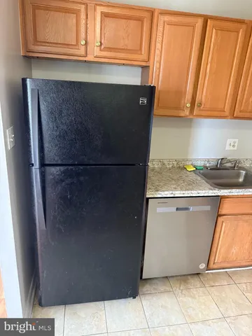 a kitchen with granite countertop a refrigerator and a stove