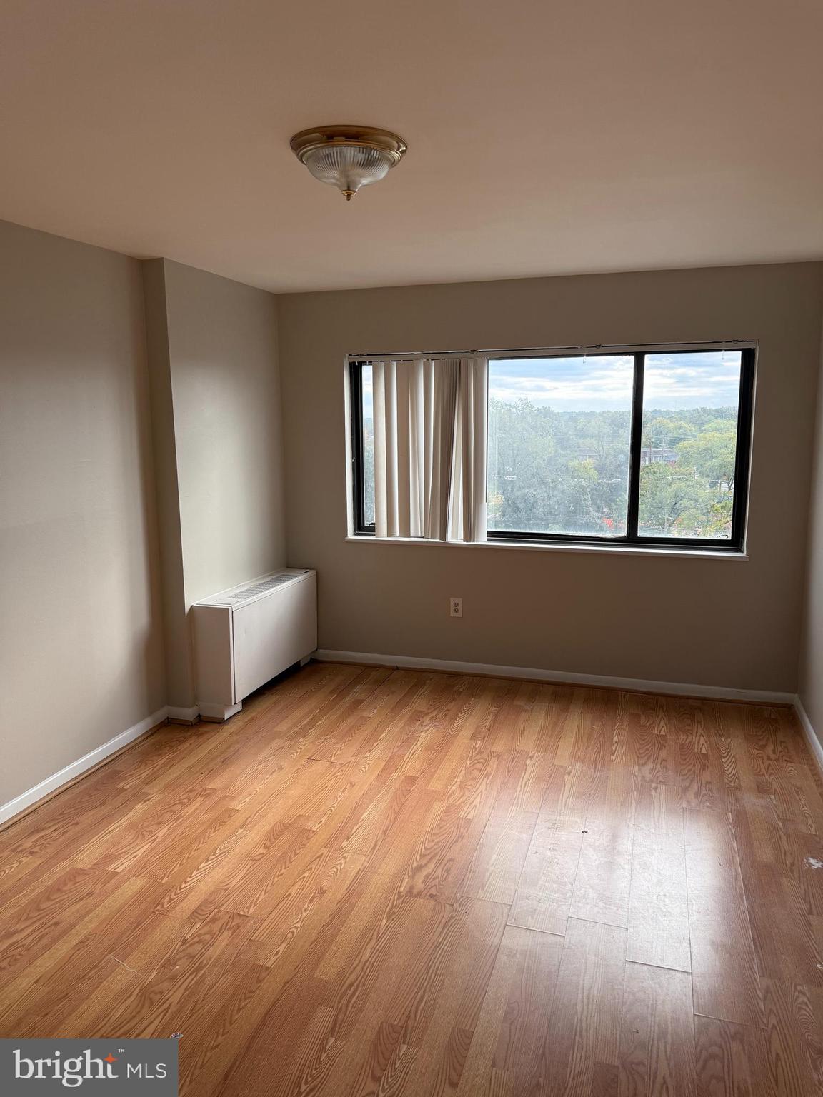 8830 Piney Branch Road, Unit 1004 Silver Spring, MD 20903 - Photo 7 of 16 an empty room with wooden floor and windows