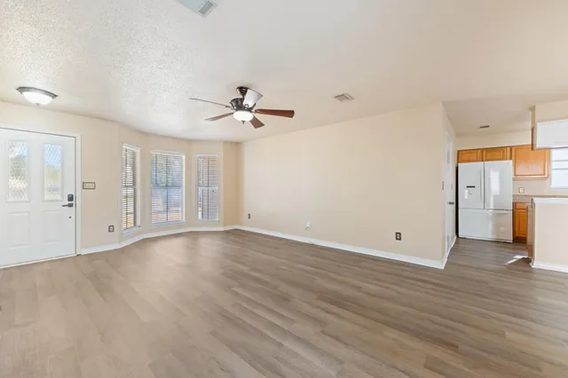 a view of a kitchen with wooden floor and electronic appliances