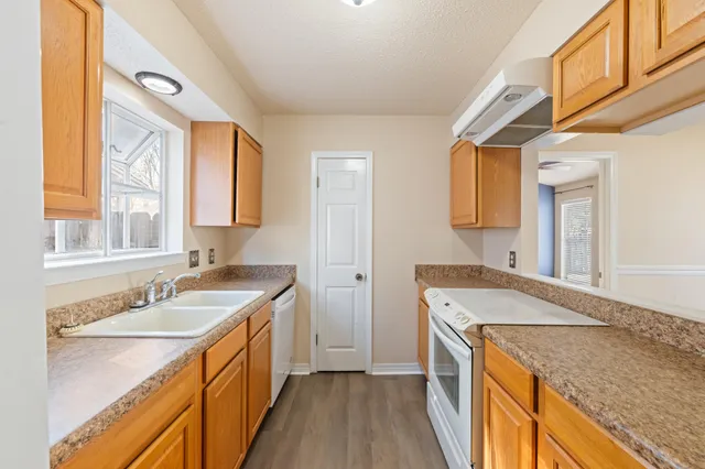 a bathroom with a granite countertop sink and a window