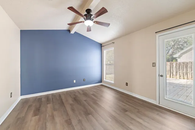 an empty room with closet and a chandelier fan