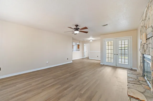 an empty room with windows fireplace and a sink