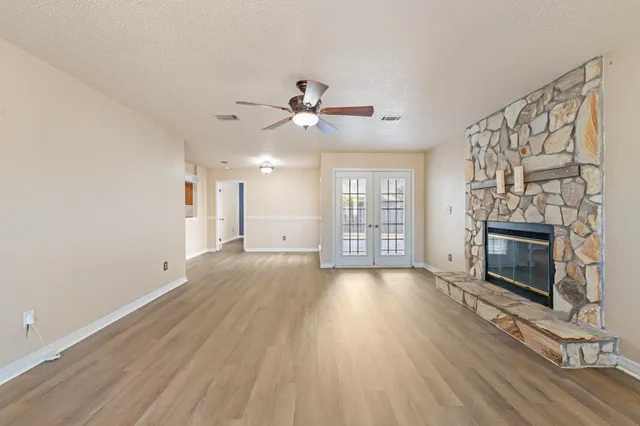 a view of an empty room with a fireplace and a window