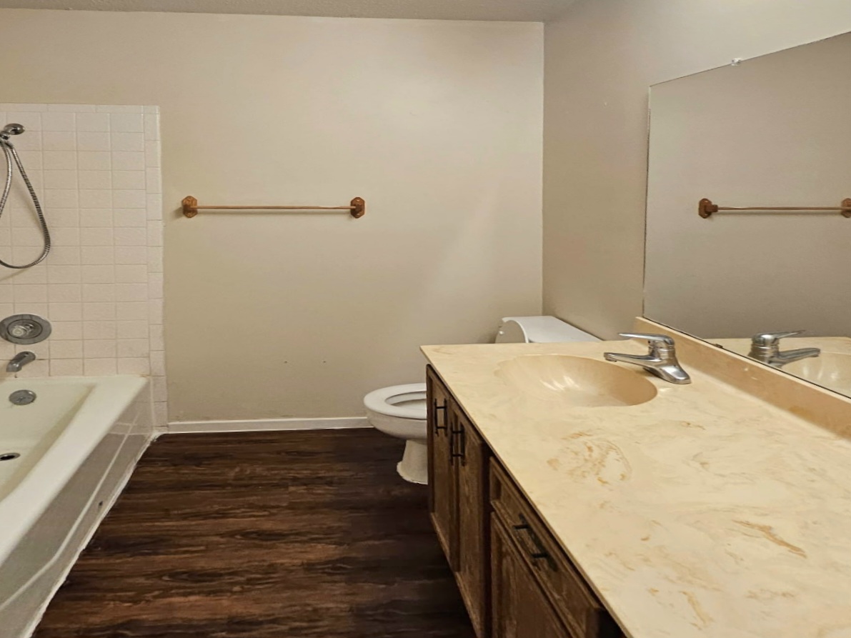 802 Kimberly Street, Unit A Georgetown, TX 78628 - Photo 4 of 7 Full bathroom featuring vanity, dark LVP flooring, and shower/tub combination