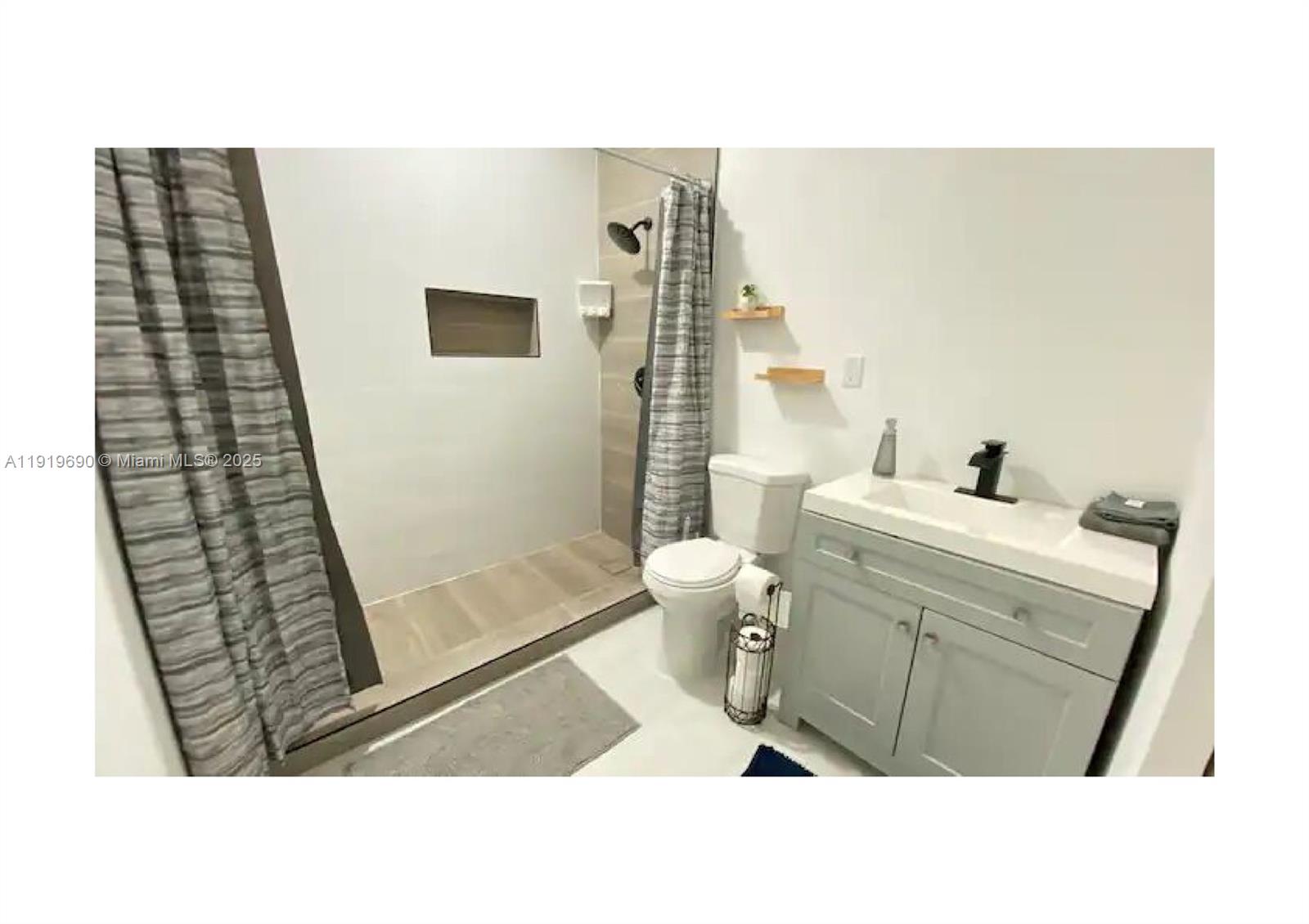 843-845 Northwest 3rd Street, Unit A Miami, FL 33128 - Photo 11 of 20 a bathroom with a sink a toilet a mirror and shower