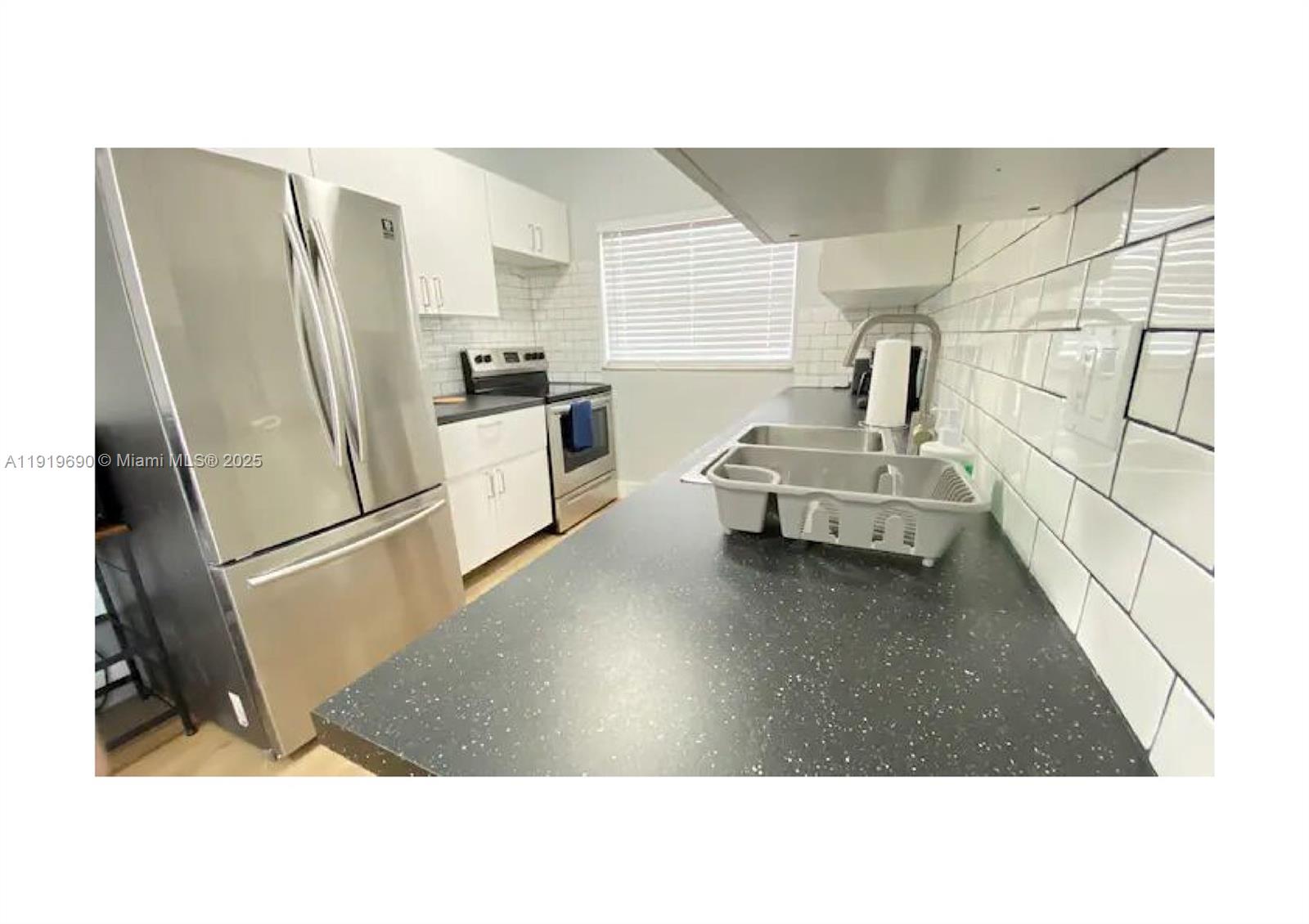 843-845 Northwest 3rd Street, Unit A Miami, FL 33128 - Photo 5 of 20 a kitchen with a refrigerator and a sink