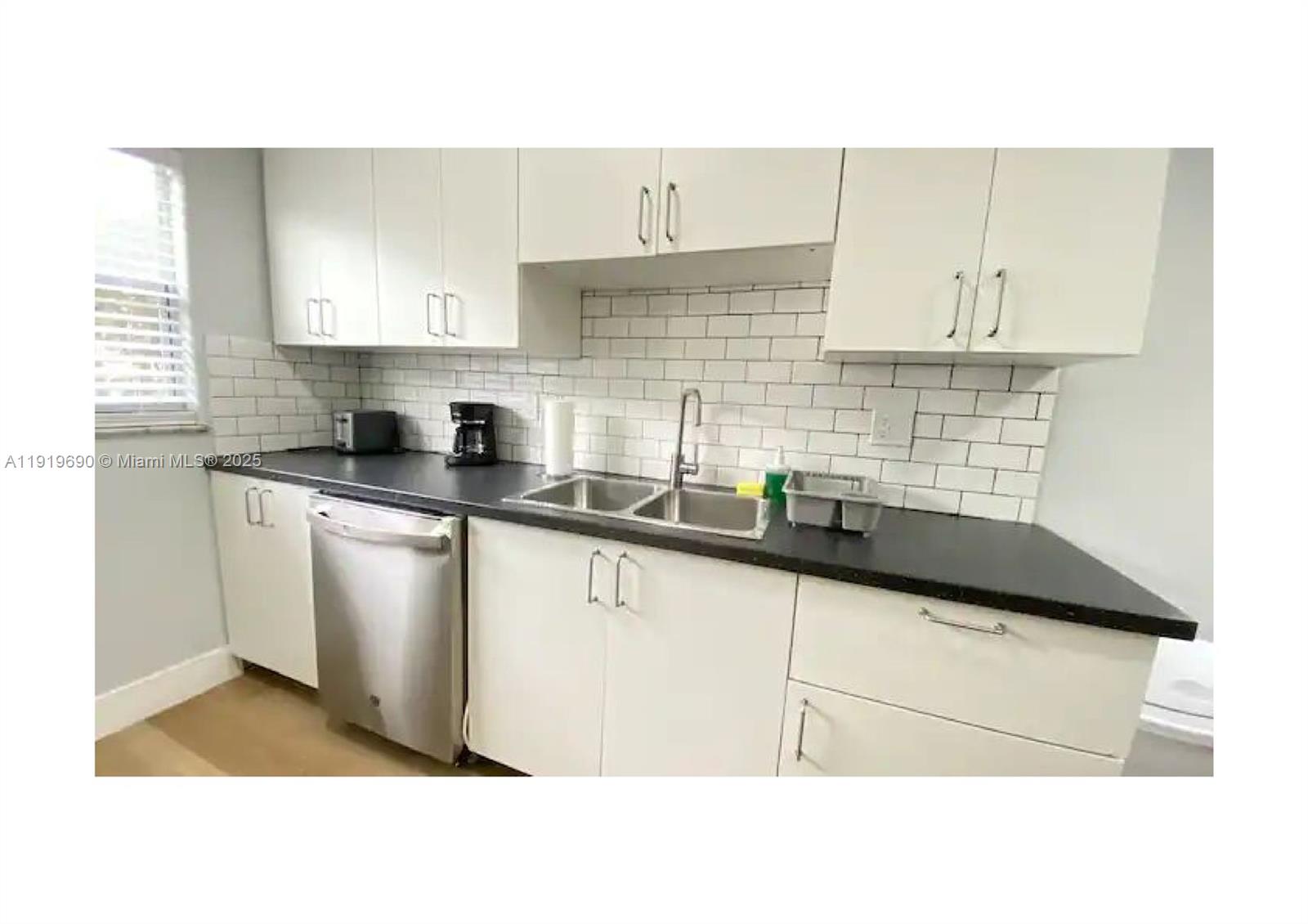 843-845 Northwest 3rd Street, Unit A Miami, FL 33128 - Photo 7 of 20 a kitchen with granite countertop a sink stainless steel appliances and cabinets