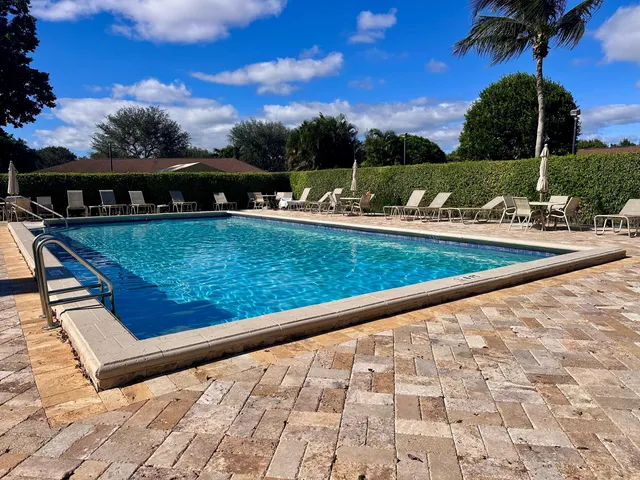 a view of a patio with a table chairs and a swimming pool