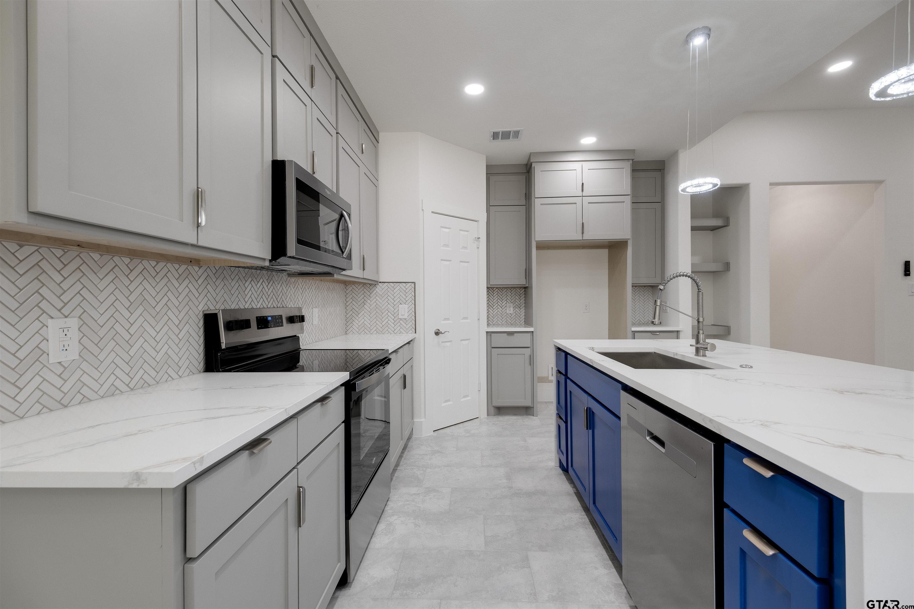 201 Victory Street Palestine, TX 75803 - Photo 13 of 37 a kitchen with stainless steel appliances granite countertop a sink stove and refrigerator