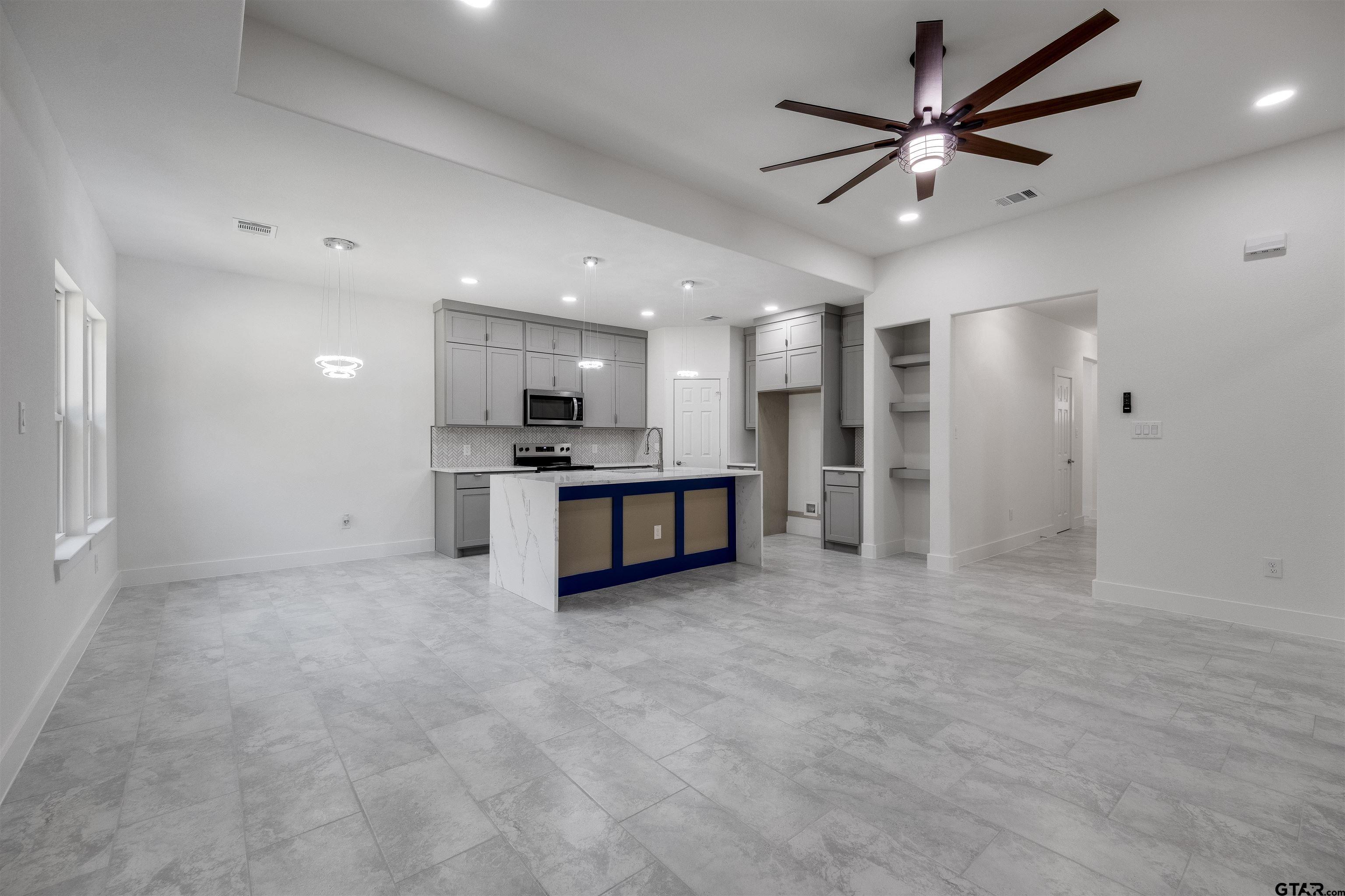 201 Victory Street Palestine, TX 75803 - Photo 14 of 37 an empty room with stainless steel appliances kitchen island a sink and a refrigerator