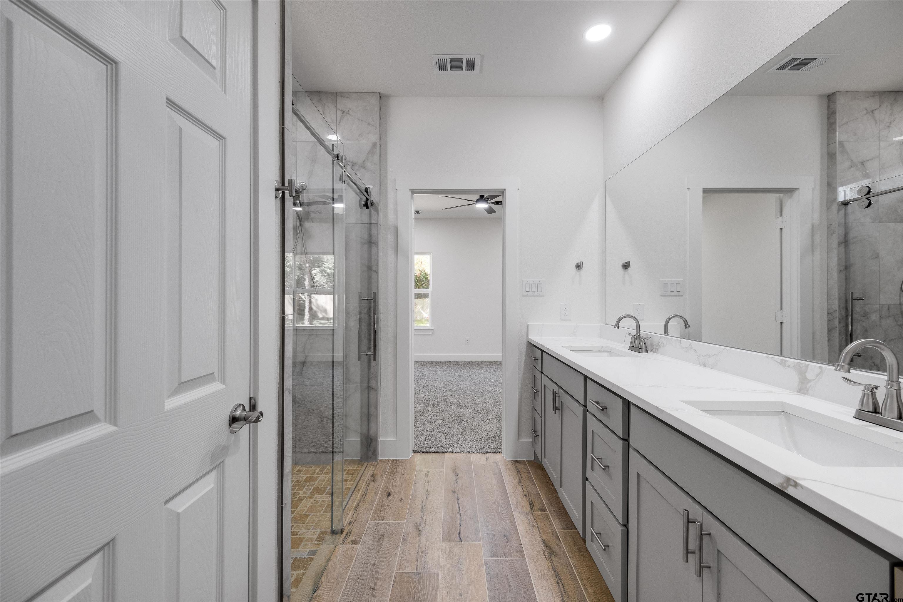 201 Victory Street Palestine, TX 75803 - Photo 19 of 37 a bathroom with a double vanity sink mirror and shower