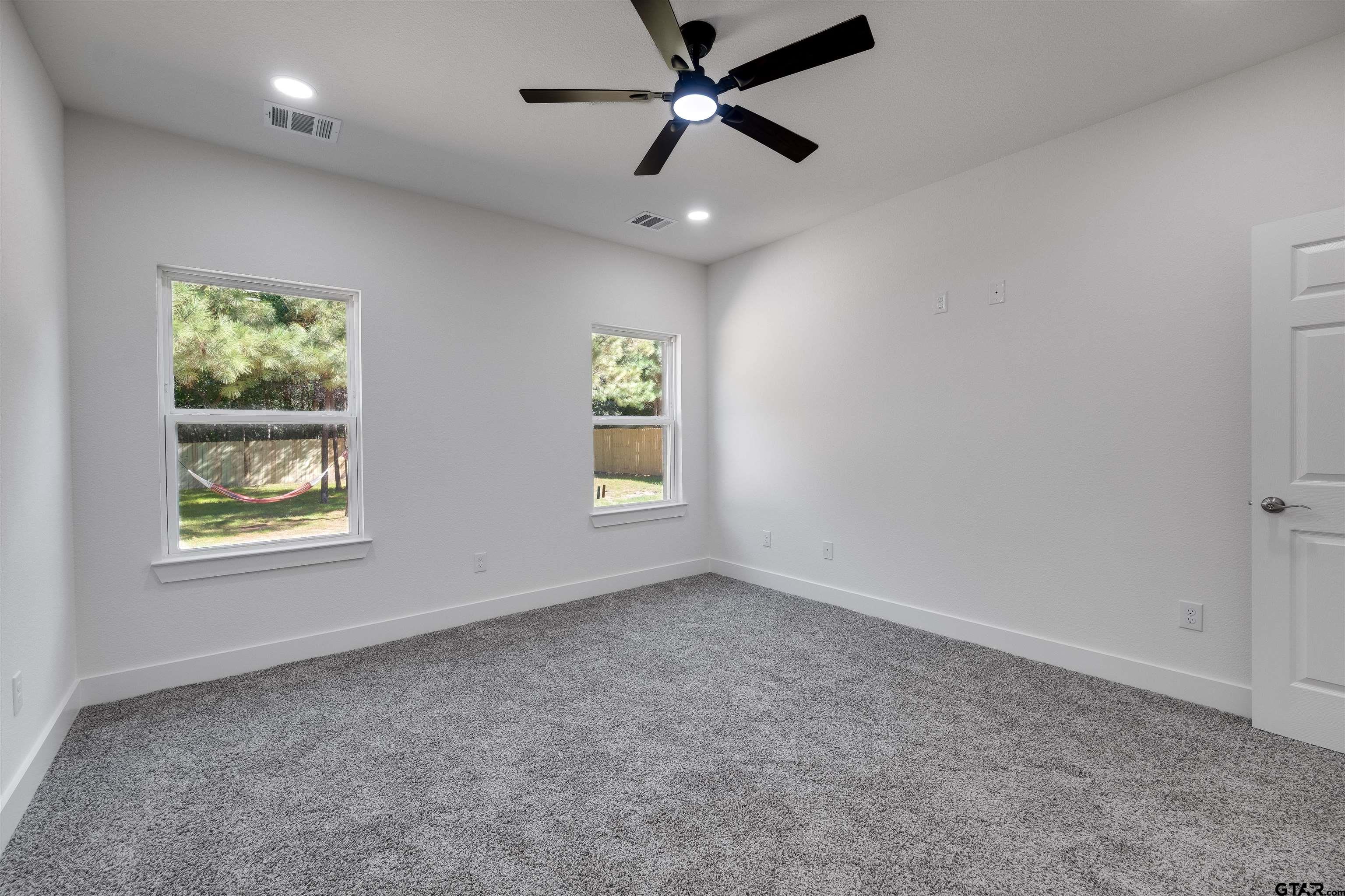 201 Victory Street Palestine, TX 75803 - Photo 28 of 37 an empty room with windows and ceiling fan