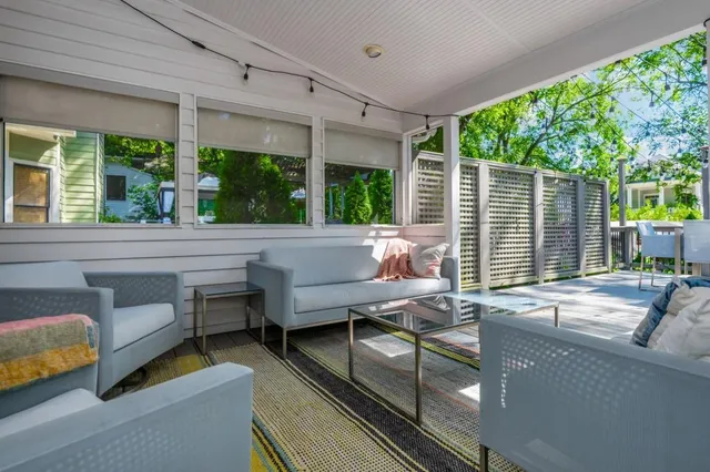 a backyard of a house with table and chairs under an umbrella