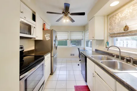 a kitchen with stainless steel appliances granite countertop a sink and a stove