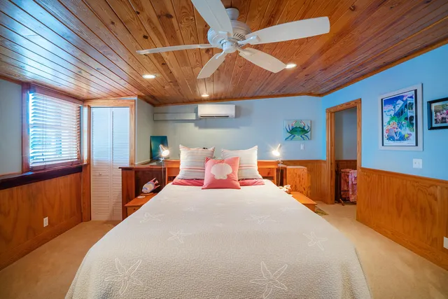 a large bed sitting in a bedroom next to a window