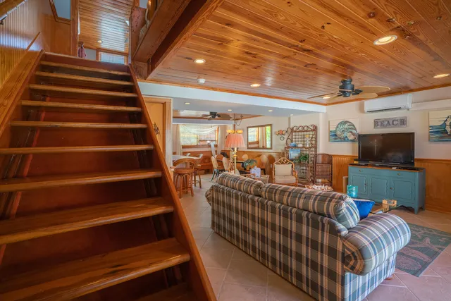 a living room with furniture a flat screen tv and a chandelier
