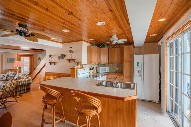 a kitchen with stainless steel appliances granite countertop sink stove refrigerator and cabinets