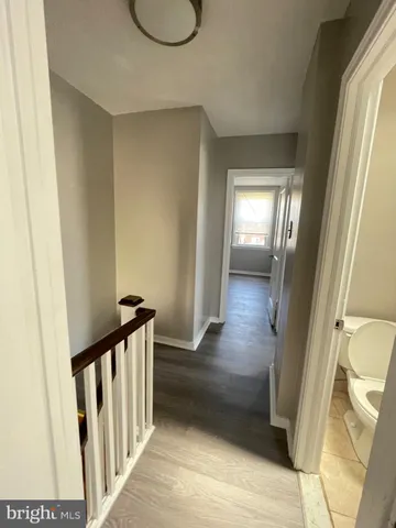 a view of a hallway with wooden floor and stairs