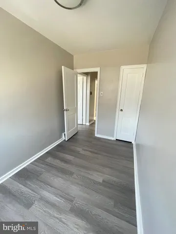 an empty room with wooden floor and mirror