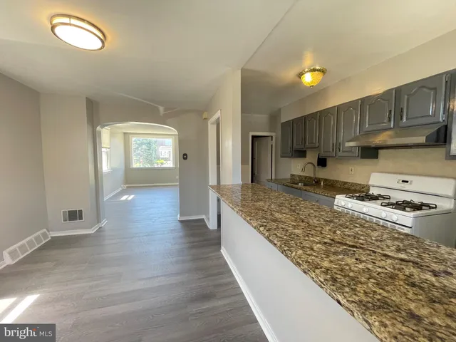 a kitchen with wooden floors and a granite counter tops