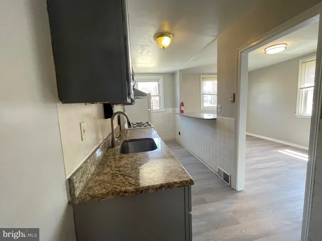 a kitchen with granite countertop a sink and a stove top oven