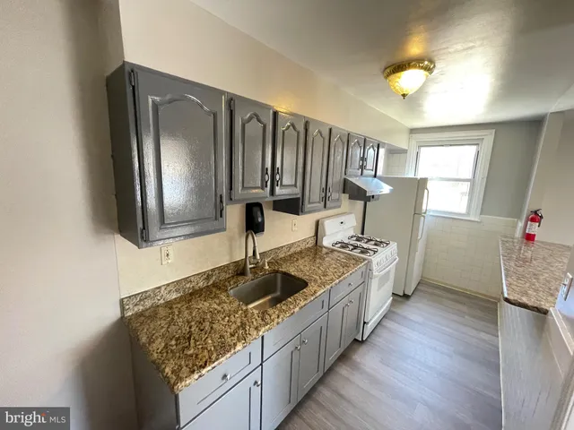 a kitchen with sink stove and refrigerator