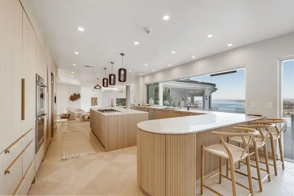 a large kitchen with stainless steel appliances a sink and cabinets