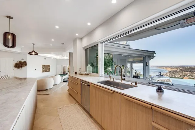 a living room with furniture kitchen view and a chandelier