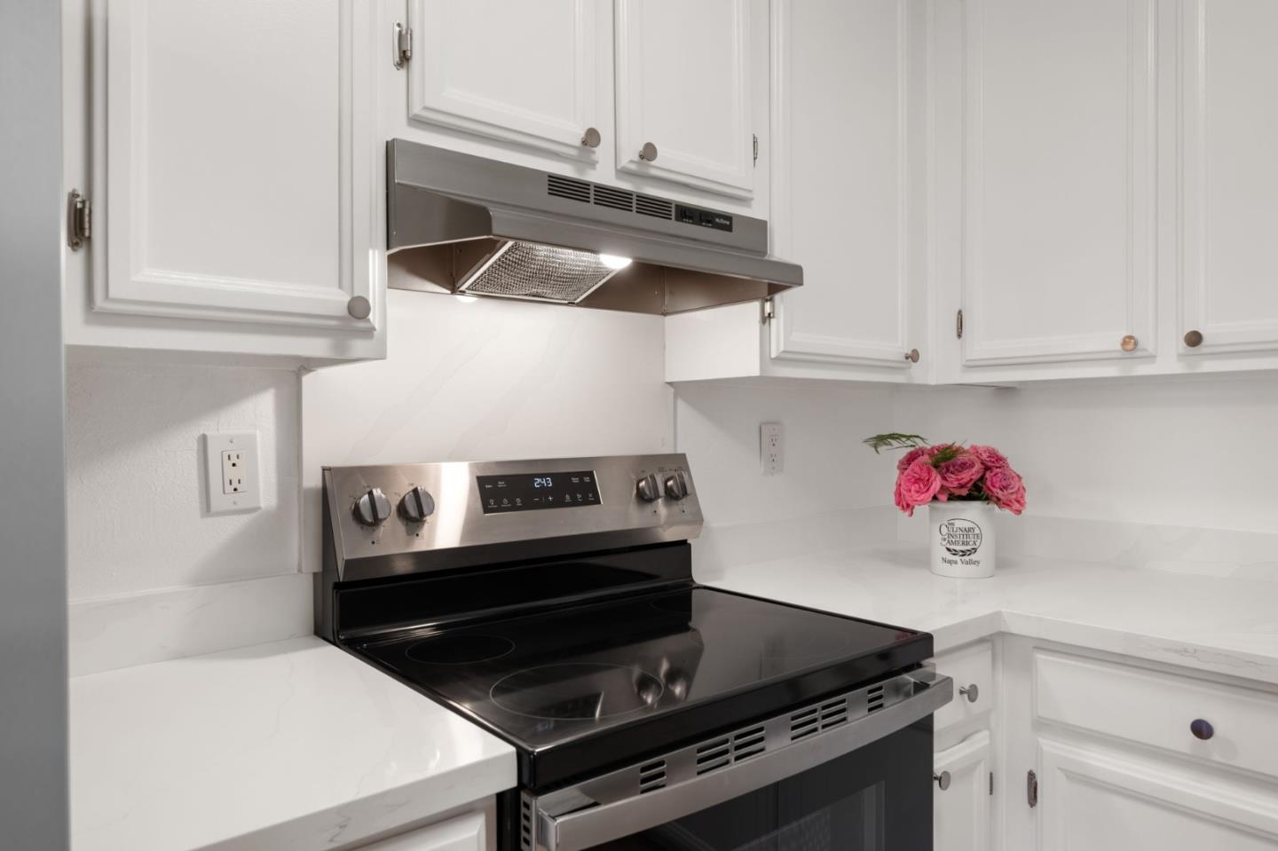 473 Costa Mesa Terrace, Unit C Sunnyvale, CA 94085 - Photo 13 of 40 a kitchen with a stove and white cabinets