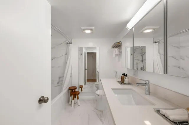 a bathroom with a tub a sink and mirror