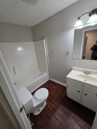a bathroom with a sink a toilet a mirror and shower