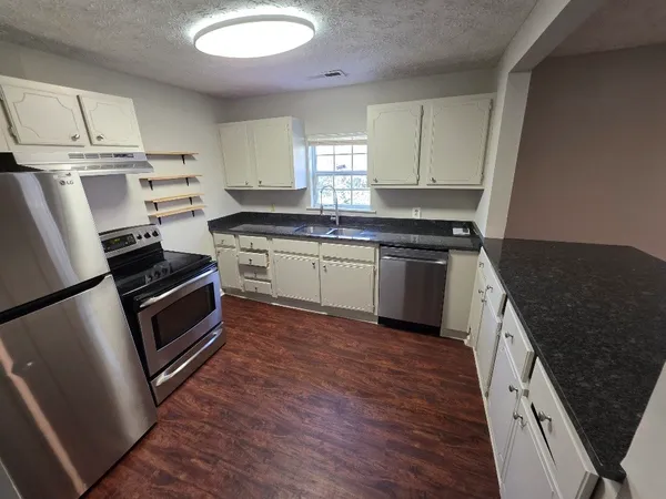 a kitchen with stainless steel appliances granite countertop a stove a sink and a refrigerator