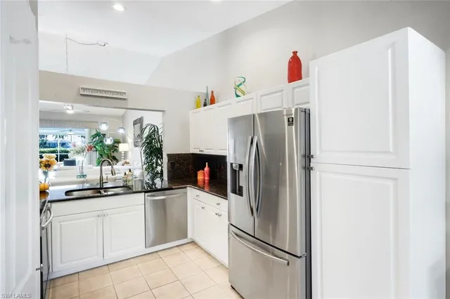 a kitchen with a refrigerator and white cabinets