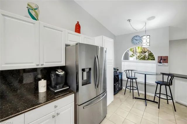 a kitchen with stainless steel appliances granite countertop a refrigerator a stove and a sink