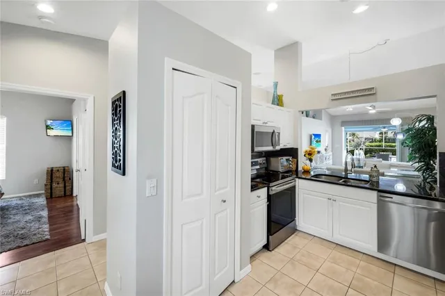 a kitchen with white cabinets and appliances
