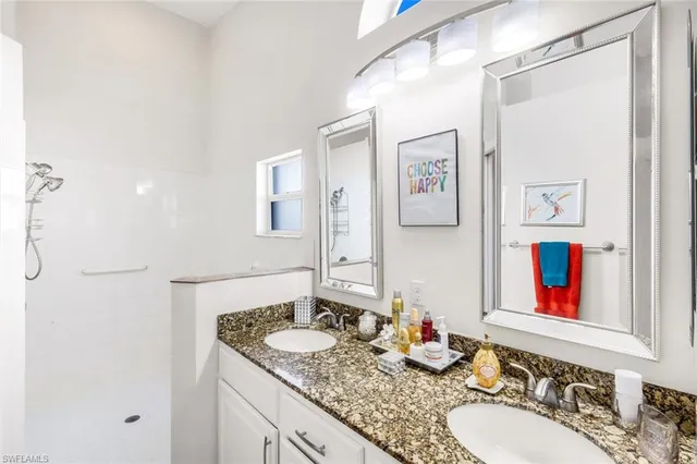 a bathroom with double vanity sinks and a shower