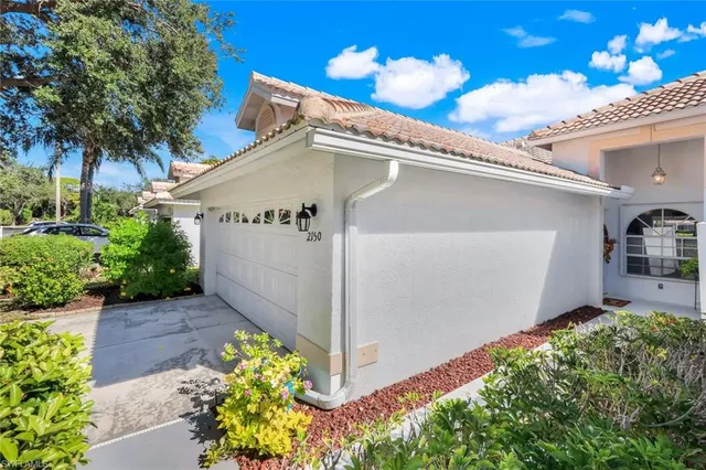 two view of a house with a yard and palm trees