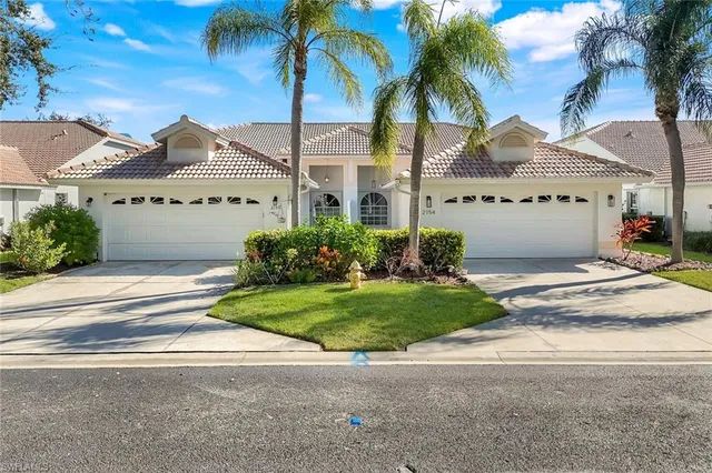 a view of a big house with a big yard and potted plants in front of house