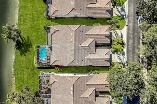 an aerial view of residential houses with outdoor space and trees
