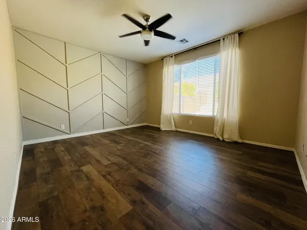 a view of a livingroom with wooden floor and a ceiling fan
