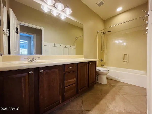 a spacious bathroom with a double vanity sink a large mirror and a bathtub