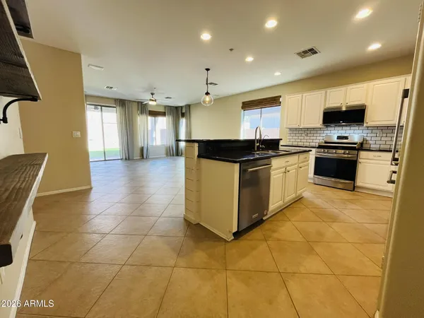 a kitchen with stainless steel appliances granite countertop a stove top oven a sink a counter top space and cabinets