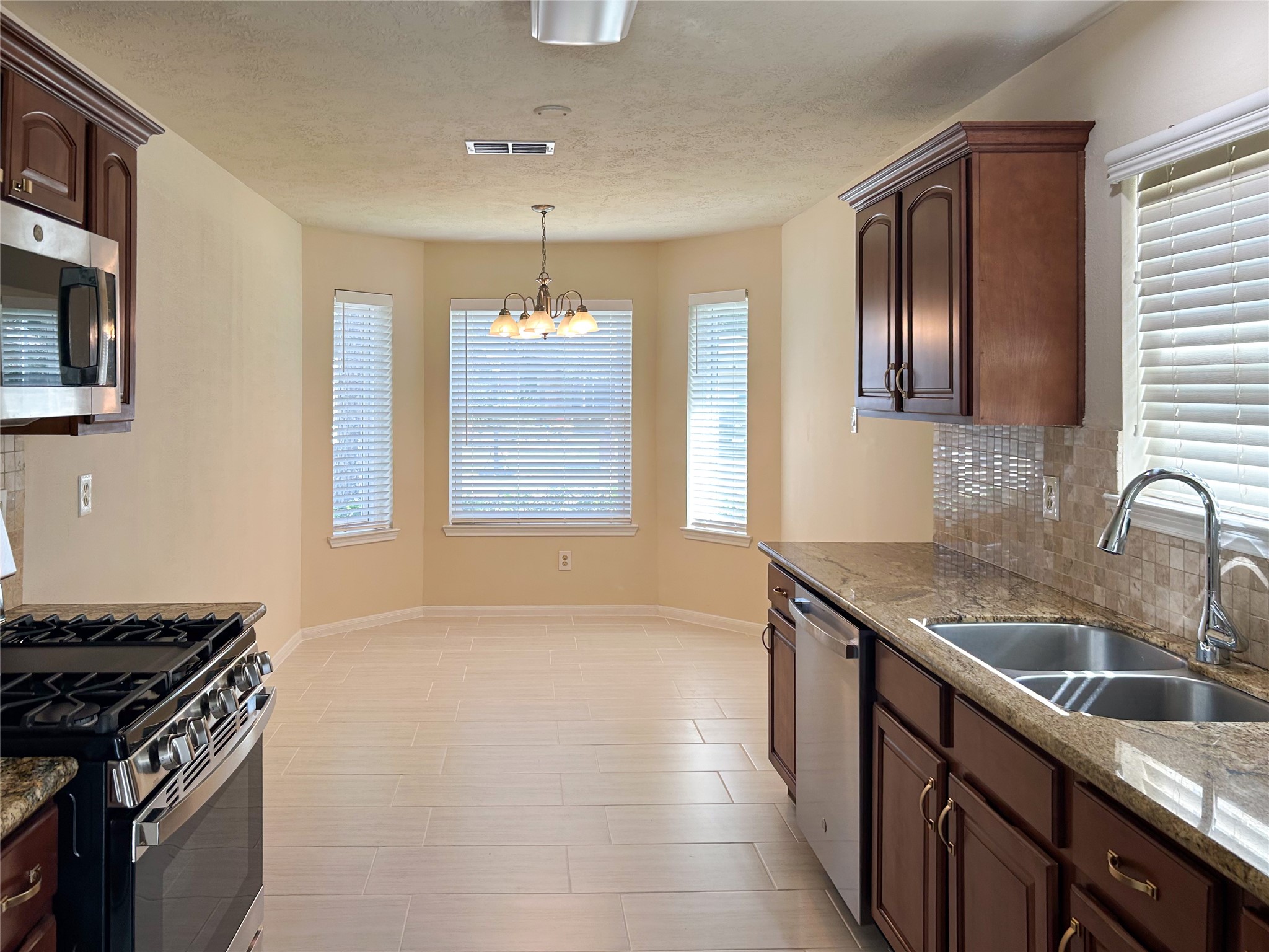 29219 Waltham Street Spring, TX 77386 - Photo 5 of 23 a kitchen that has a sink stainless steel appliances a window and a counter space